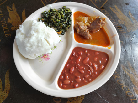 Traditional local meal: Ugali, beans, greens and goat